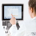 Tekniker betjener en Labfors 5 bioreaktor via INFORS HT berøringsskjerm