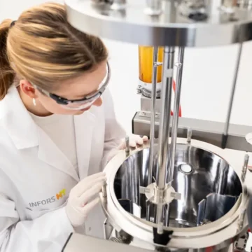 Tekniker inspiserer den åpne beholderen på en Infors Techfors-S 2 bioreaktor